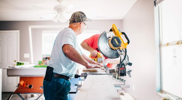 two people using powertools to remodel a kitchen